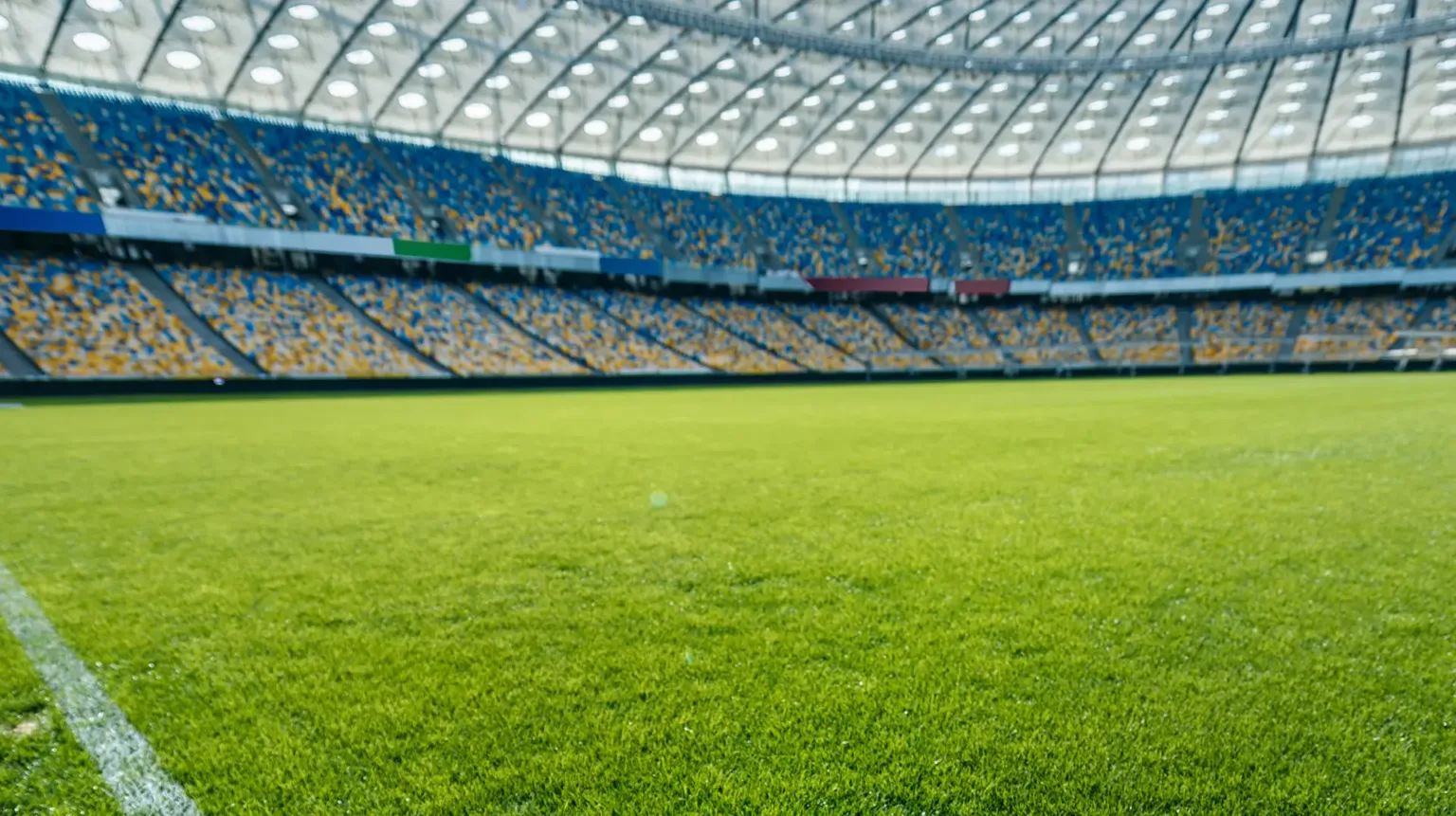 Fußballstadion mit gepflegtem Spielfeld und Tribüne voller Fans im Hintergrund