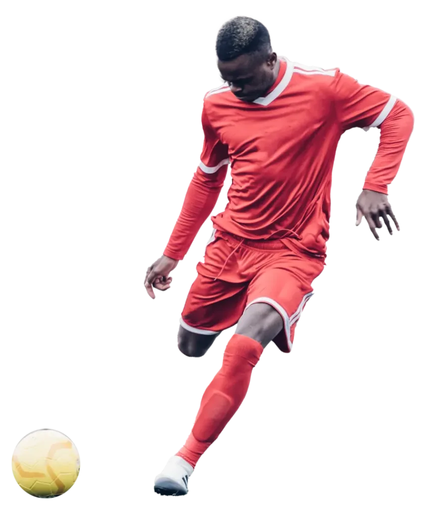 Fußballer im roten Trikot bereit, einen Ball zu kicken, während eines Spiels.